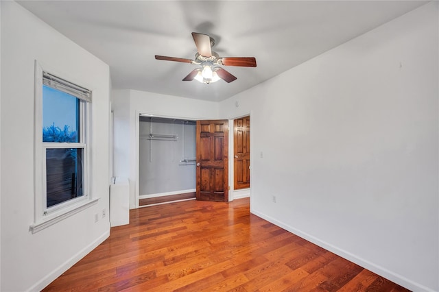 unfurnished bedroom with wood-type flooring, a closet, and ceiling fan