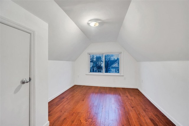 bonus room with vaulted ceiling and dark hardwood / wood-style floors