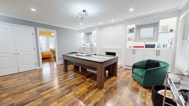 rec room with ornamental molding, dark hardwood / wood-style flooring, and a baseboard radiator