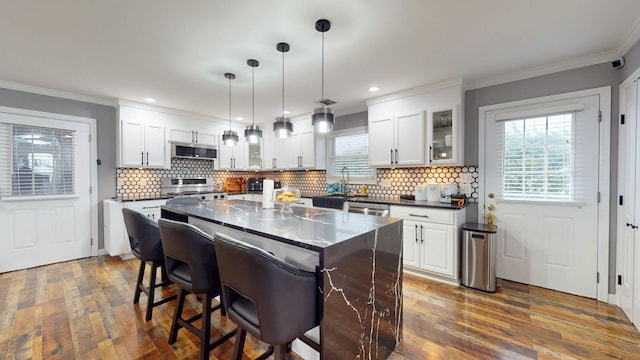 kitchen with a center island, white cabinets, and decorative light fixtures