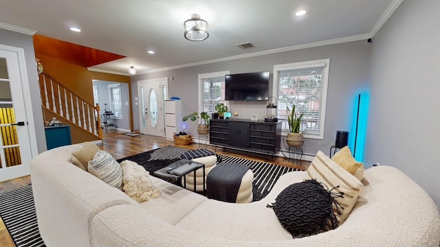 living room with wood-type flooring, ornamental molding, and a wealth of natural light