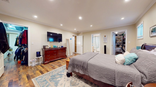 bedroom featuring hardwood / wood-style flooring, a walk in closet, and a closet