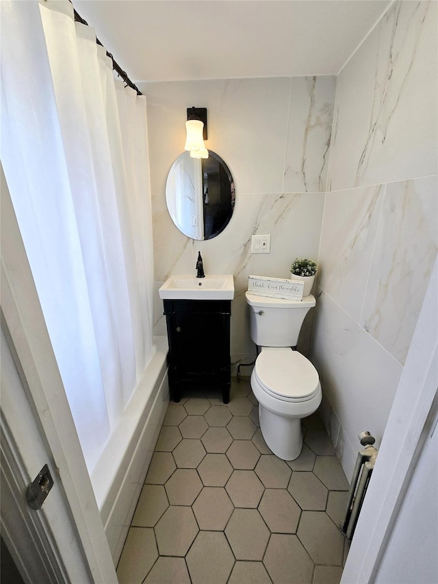 full bathroom featuring shower / bath combo with shower curtain, vanity, toilet, and tile walls