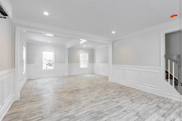 empty room with ornamental molding and light wood-type flooring