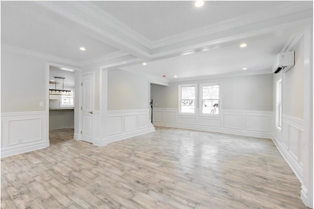 unfurnished room featuring ornamental molding, an AC wall unit, and light wood-type flooring