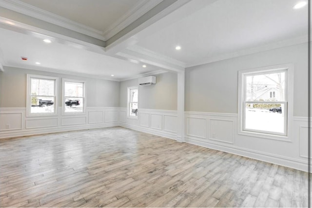 unfurnished room with beam ceiling, ornamental molding, a wall mounted AC, and light wood-type flooring