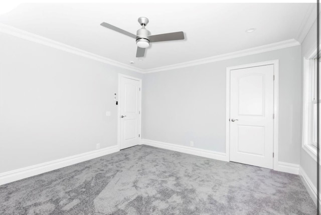 carpeted spare room with crown molding and ceiling fan