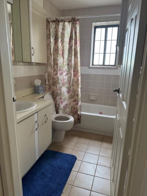 full bathroom featuring tile patterned flooring, vanity, shower / bath combination with curtain, and toilet