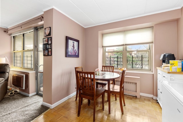 dining space with crown molding, radiator heating unit, and light parquet floors