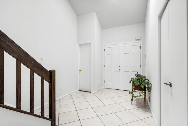 foyer entrance with stairs and baseboards