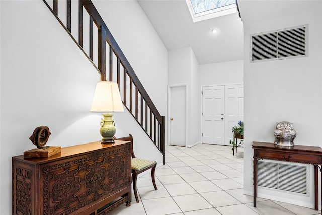 entryway with a skylight, visible vents, stairs, light tile patterned flooring, and recessed lighting