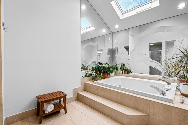 bathroom featuring vaulted ceiling with skylight, a garden tub, a shower stall, and tile patterned floors