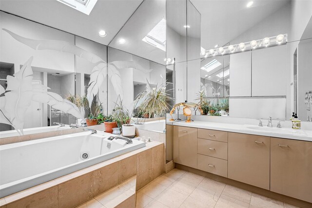 full bath featuring a whirlpool tub, a skylight, vanity, and tile patterned floors