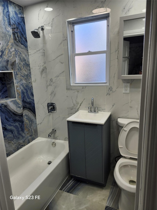 full bathroom with tiled shower / bath, tile walls, vanity, and toilet