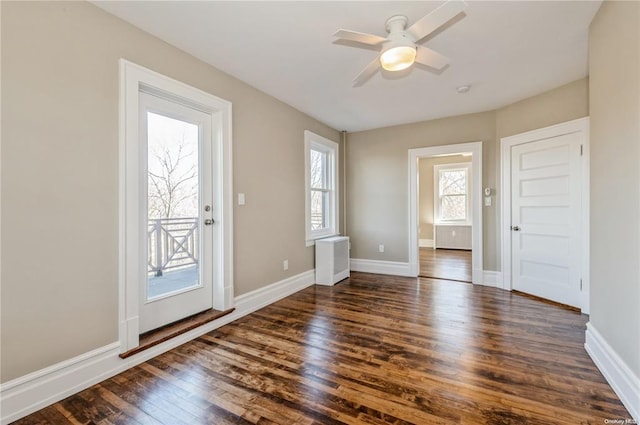 entryway with dark hardwood / wood-style floors, radiator, and ceiling fan