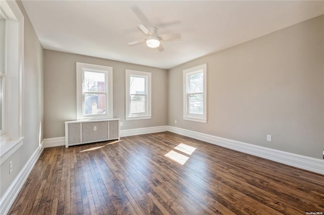 spare room with radiator, dark hardwood / wood-style floors, and ceiling fan