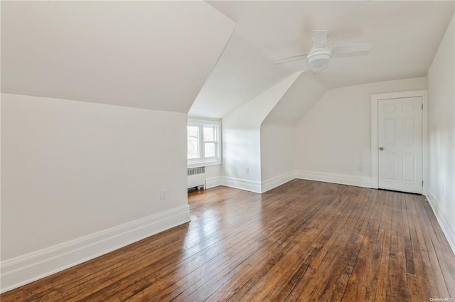 bonus room with dark wood-type flooring, ceiling fan, radiator, and vaulted ceiling