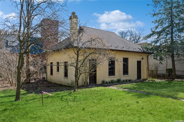 back of house with a lawn