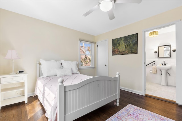 bedroom featuring baseboards, ensuite bathroom, ceiling fan, and wood finished floors