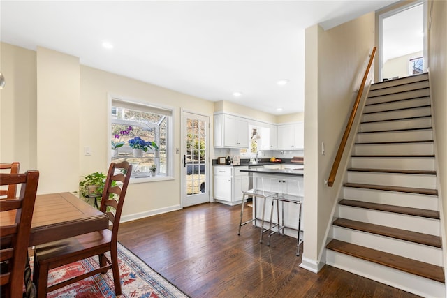 dining space with stairs, dark wood-style floors, and baseboards