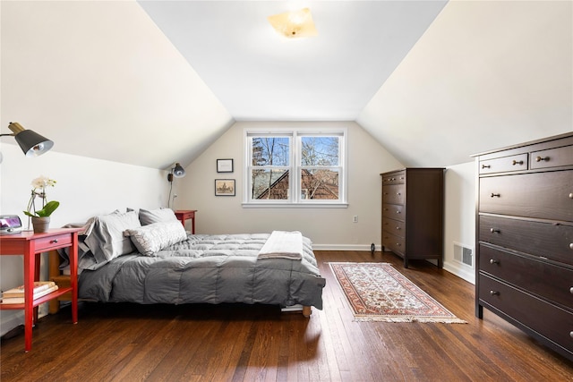 bedroom featuring vaulted ceiling, dark wood-style floors, and visible vents