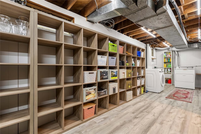 unfinished basement with separate washer and dryer and wood finished floors