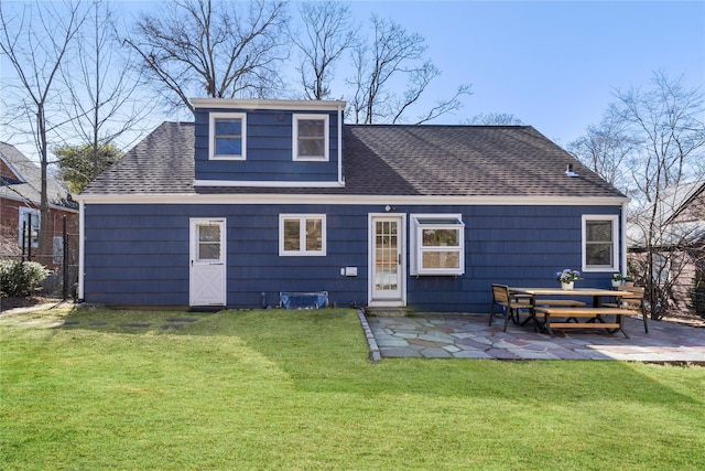 back of house with a patio area, a lawn, and roof with shingles