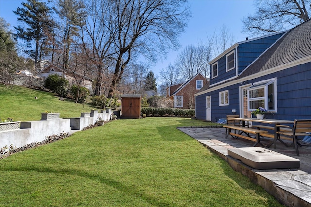 view of yard with an outdoor structure, a storage shed, and a patio