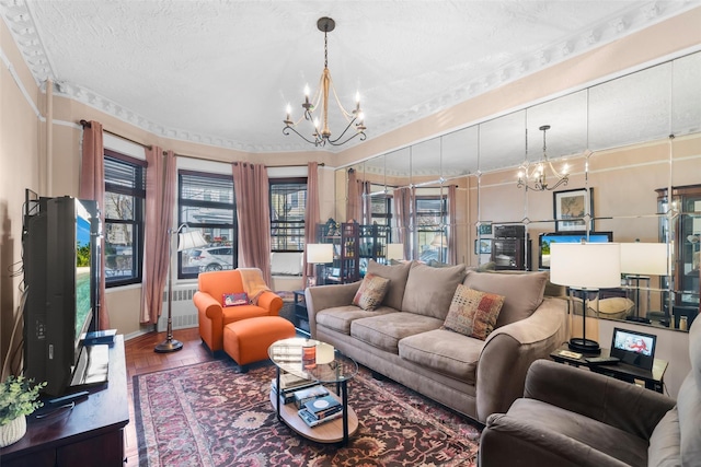 living room featuring an inviting chandelier, wood-type flooring, and a textured ceiling