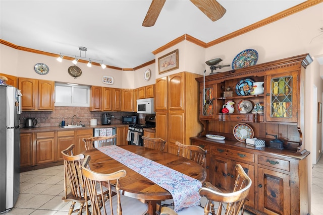 dining room featuring ceiling fan, ornamental molding, sink, and light tile patterned floors