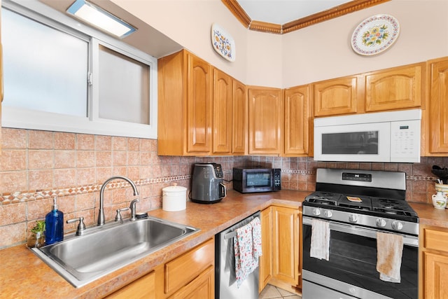 kitchen featuring tasteful backsplash, ornamental molding, appliances with stainless steel finishes, and sink