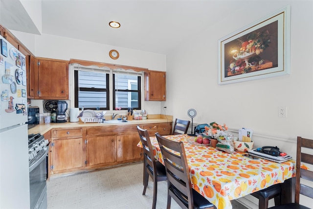 kitchen with range with gas stovetop, sink, and white fridge