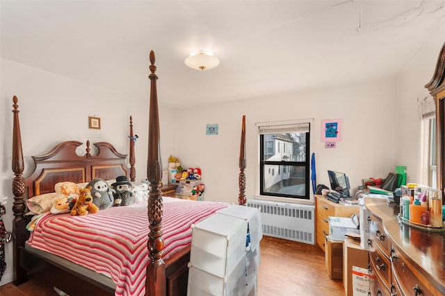 bedroom featuring radiator heating unit and light hardwood / wood-style flooring