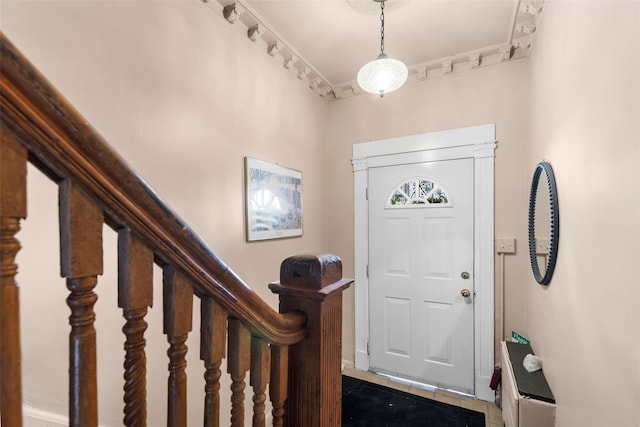 foyer featuring crown molding and dark tile patterned floors