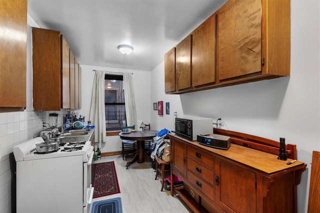 kitchen featuring tasteful backsplash, sink, and gas range gas stove