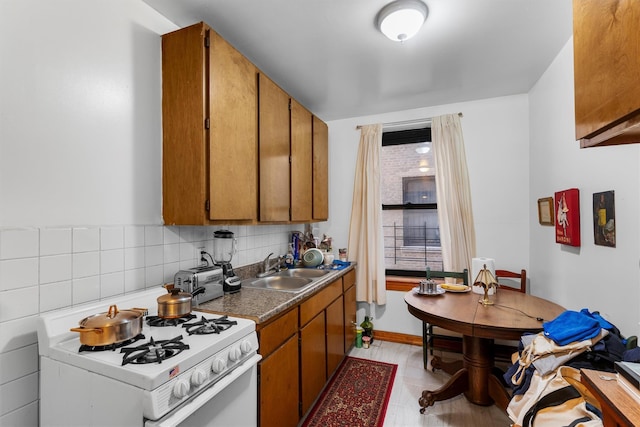 kitchen with sink, decorative backsplash, and white gas stove