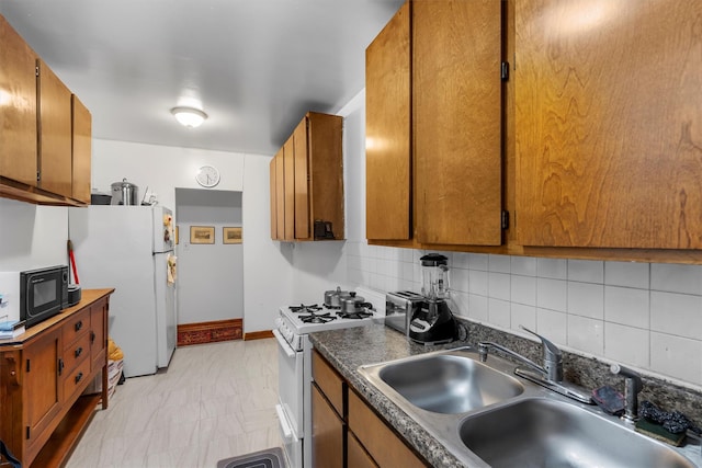 kitchen featuring sink, white appliances, and backsplash