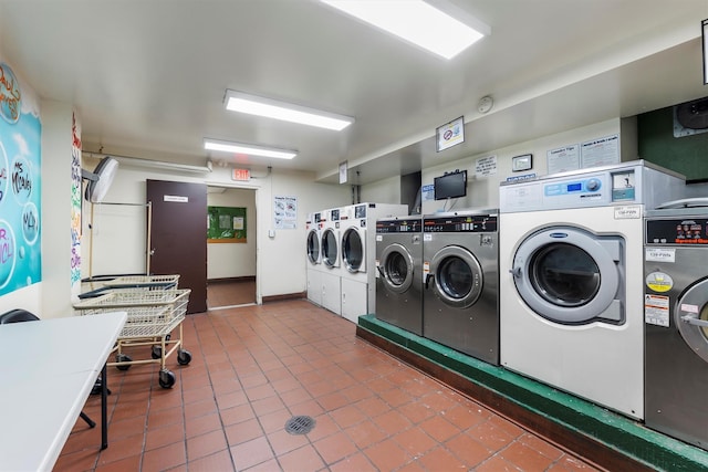 laundry room with tile patterned floors, washing machine and dryer, and stacked washing maching and dryer