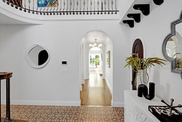 hallway with arched walkways and baseboards