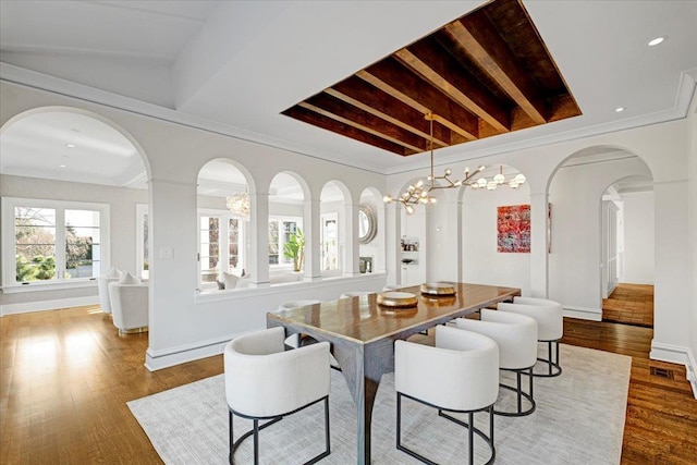 dining space featuring visible vents, crown molding, baseboards, and wood finished floors