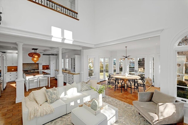 living room featuring ornate columns, a high ceiling, and french doors