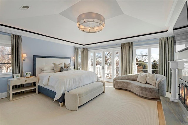 bedroom featuring visible vents, a premium fireplace, ornamental molding, access to exterior, and french doors