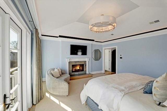 carpeted bedroom featuring lofted ceiling, a warm lit fireplace, visible vents, and crown molding