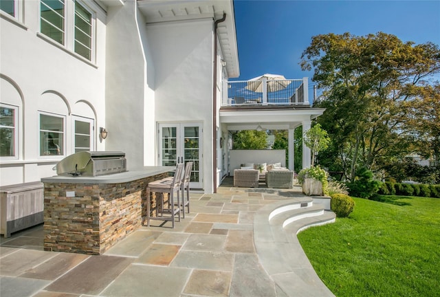 view of patio with french doors, outdoor dry bar, an outdoor hangout area, a balcony, and exterior kitchen