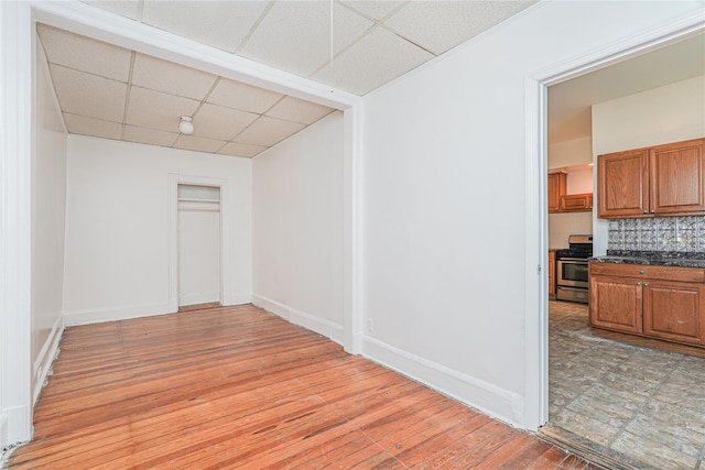 spare room featuring light hardwood / wood-style flooring and a paneled ceiling