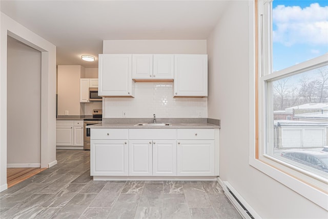 kitchen featuring tasteful backsplash, sink, white cabinets, baseboard heating, and stainless steel appliances