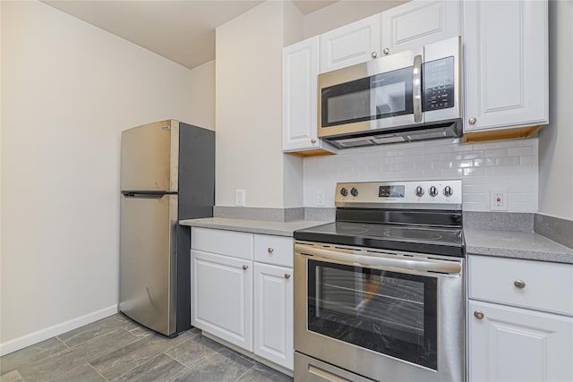 kitchen with tasteful backsplash, white cabinetry, and appliances with stainless steel finishes