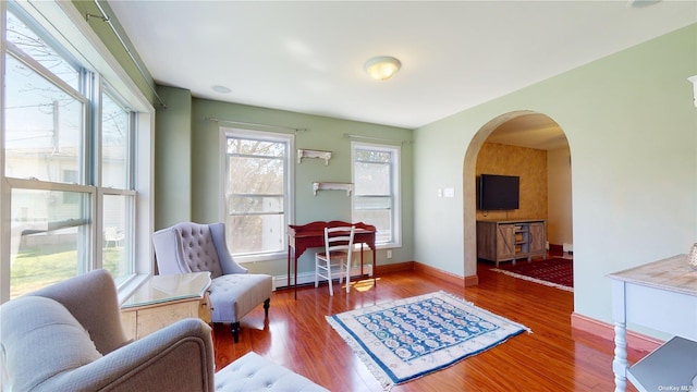 living area with a baseboard heating unit and hardwood / wood-style floors