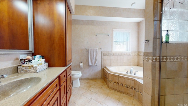 bathroom featuring vanity, plenty of natural light, a relaxing tiled tub, and toilet