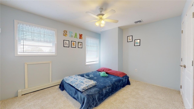 carpeted bedroom featuring multiple windows, a baseboard radiator, and ceiling fan